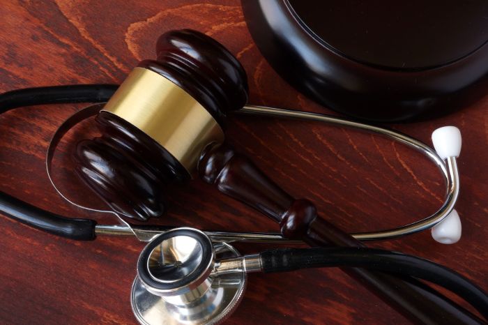 67198760 - gavel and stethoscope on a wooden surface.